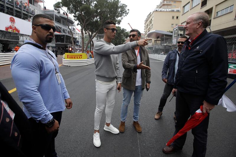 Cristiano Ronaldo, second left, walks at the pit line ahead of the second practice session. AP Photo