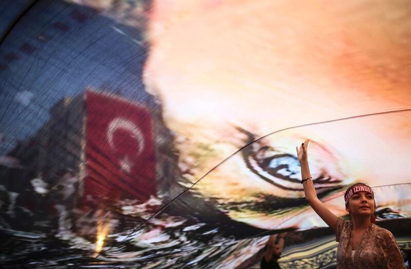 A Turkish girl gestures under a huge picture of modern Turkey's founder Mustafa Kemal Ataturk at a rally in Gundogdu Square in Izmir on August 4, 2016, protesting against the failed July 15 military coup attempt. Emre Tazegul / AFP 

 

