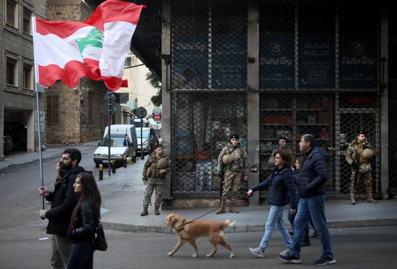 Army soldiers look on as Lebanese anti-government protesters march toward the capital Beirut's downtown district. AFP