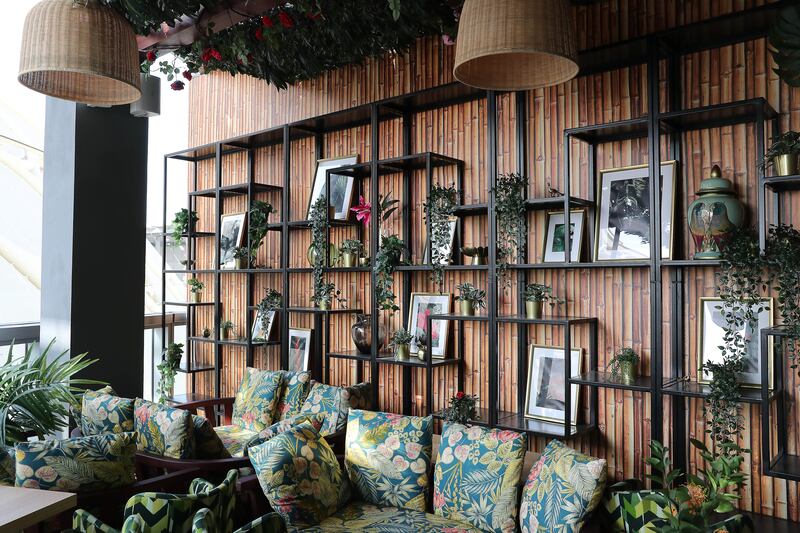 Shelves across the walls are decorated with framed photos and vases