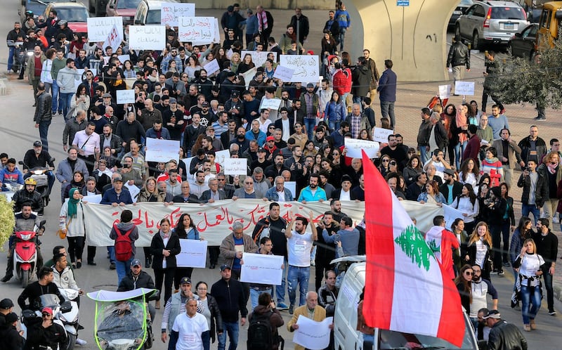 epa07278361 Lebanese activists from the civil society hold placards and carry banners with reading 'We will not pay the price' as they chant slogans against corrupt politicians during a protest in front the Ministry of Labor in the southern suburb of Beirut, Lebanon, 12 January 2019. Hundreds of Lebanese activists protest in front the Lebanese Ministry of Labor and marched towards the Lebanese Ministry of Health, rejecting unfair taxes on gasoline and value added (TVA) and all indirect taxes, calling on the government to protect citizens right to work and right to have access to medical care.  EPA/NABIL MOUNZER