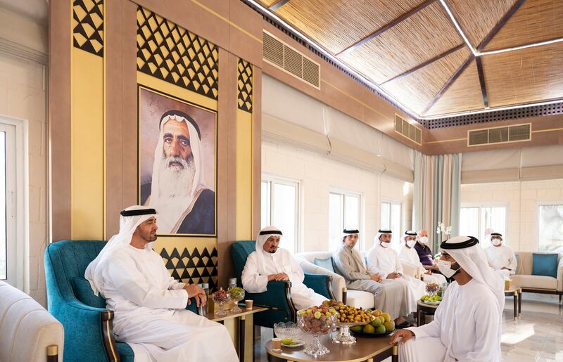 AJMAN, UNITED ARAB EMIRATES - May 14, 2021: HH Sheikh Mohamed bin Zayed Al Nahyan, Crown Prince of Abu Dhabi and Deputy Supreme Commander of the UAE Armed Forces (L), exchanges Eid greetings with HH Sheikh Humaid bin Ammar Al Nuaimi (R). Seen with HH Sheikh Humaid bin Rashid Al Nuaimi, UAE Supreme Council Member and Ruler of Ajman (2nd L), HH Sheikh Mansour bin Zayed Al Nahyan, UAE Deputy Prime Minister and Minister of Presidential Affairs (3rd L) and other dignitaries. 

( Mohamed Al Hammadi / Ministry of Presidential Affairs )​
---