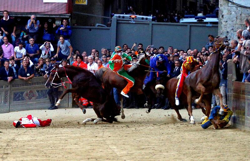 Jockeys fall off their horses during the Palio of Siena race, in Siena, Italy. Reuters