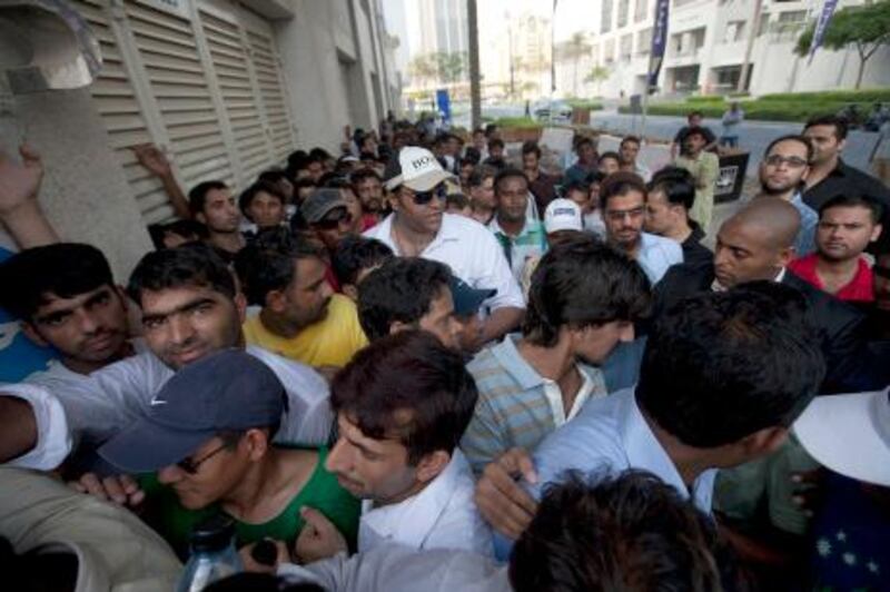 Dubai, United Arab Emirates, Sept 21 2012, people paid to wait in lines are squeezed together along the property boundry of Emaar . Emaar properties anounced that they  would be making available properties for sale, people paid to stand in lines waited for the past two days to collect a token for an opportunity to purchase property. Mike Young / The National

