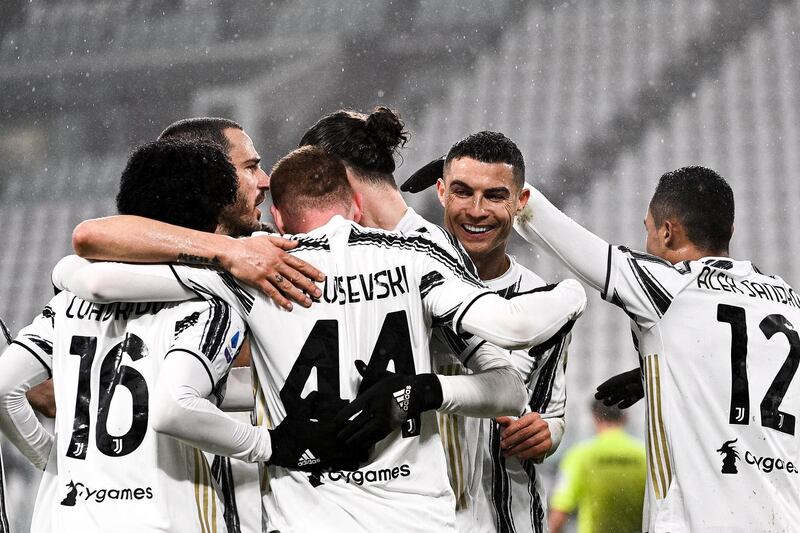 Juventus' Cristiano Ronaldo celebrates with teammates after Roma's Roger Ibanez scored an own goal. AP