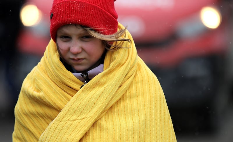 A girl in Siret, Romania, covers herself with a blanket after fleeing from Ukraine. Reuters