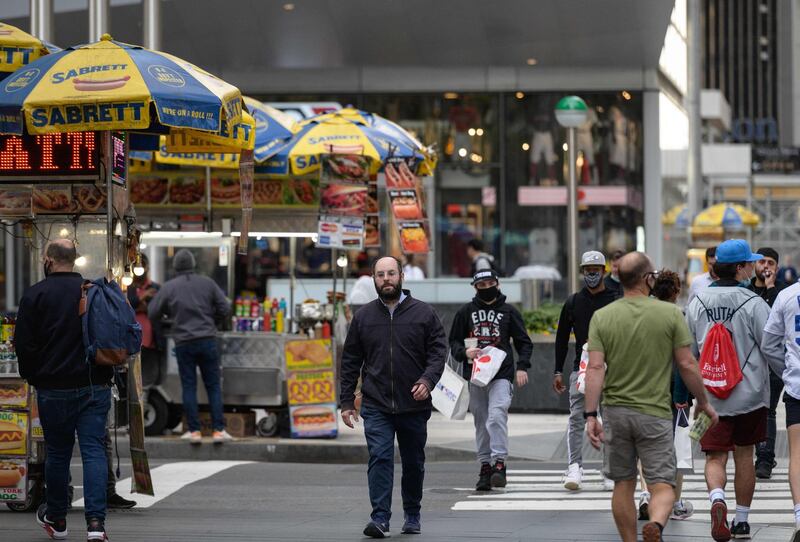 A man without a mask crosses a street in Manhattan, New York on April 27, 2021. Americans vaccinated against Covid-19 no longer need to mask up outdoors when there is no crowd, President Joe Biden said, before celebrating by taking his first short walk at the White House without the face covering. / AFP / Angela Weiss
