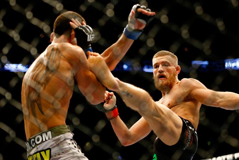 Conor McGregor kicks Max Holloway in their featherweight bout at TD Garden on August 17, 2013 in Boston, Massachusetts.