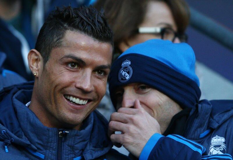 Cristiano Ronaldo of Real Madrid shares a joke with a teammate on the bench. Paul Gilham / Getty Images