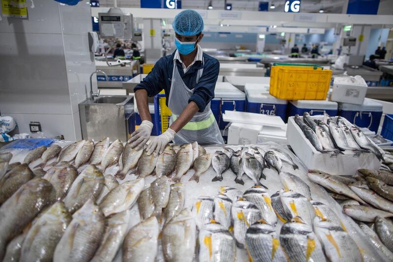 A seller wearing a protective mask at the fish market in Dubai. The Dubai authorities reopened some fish, meat and vegetables markets to the public after they were closed weeks ago to limit spread of the covid-19 coronavirus.  EPA