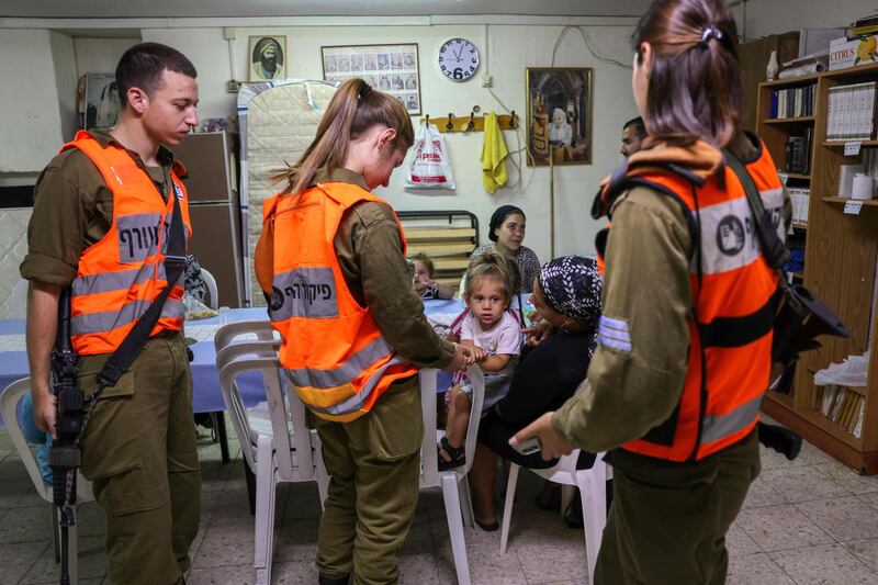 Israeli soldiers from Home Front Command visit families inside a bomb shelter in the southern Israeli city of Ashkelon, on May 18, 2021, following rocket attacks fired from the Gaza Strip. AFP