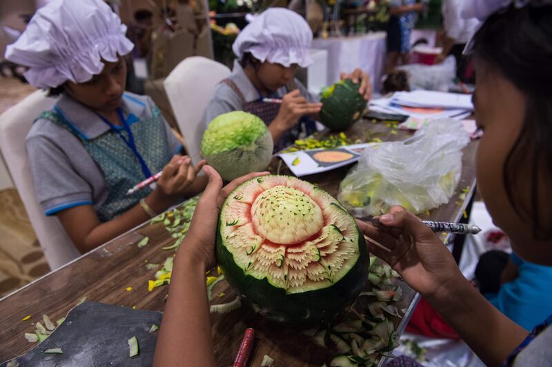 Thai girls carve floral patterns into fruits during a fruit and vegetable carving competition in Bangkok. Robert Schmidt / AFP