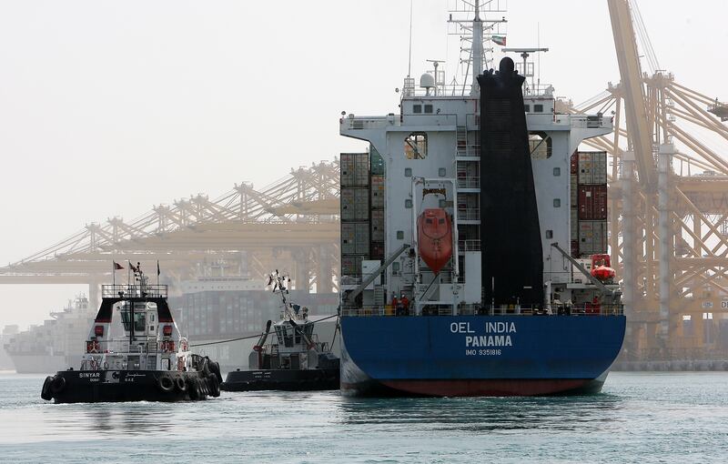 DUBAI , UNITED ARAB EMIRATES Ð Oct 06 : Tugboat pushing the Cargo ship near the terminal 2 of Jebel Ali port in Dubai. ( Pawan Singh / The National ) For Business. Story by Frank Kane