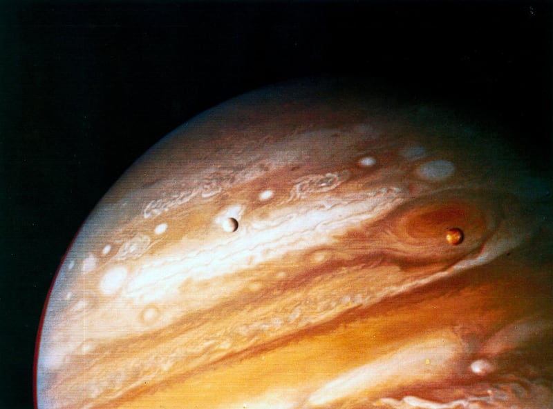 UNITED STATES - MAY 14:  Taken from 20 million kilometres away by Voyager 1, this picture shows the Great Red Spot, and two of Jupiter's four main moons; Io, which is above the Great Red Spot, and Europa. NASA launched two Voyager spacecraft in 1977 to explore the planets in the outer solar system. Voyager 1 flew past Jupiter at 278,000 kilometres in March 1979 before going on to pass Saturn in 1980. The largest planet in the solar system, Jupiter is a type of planet known as a gas giant, with an atmosphere composed mainly of hydrogen and helium. The atmosphere contains a number of large storms, the most famous of which, the Great Red Spot, is larger than the Earth and has been in existence for at least 300 years.  (Photo by SSPL/Getty Images)