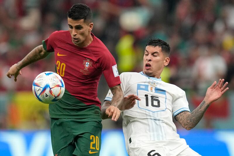 Portugal's Joao Cancelo battles with Uruguay's Mathias Olivera at the Qatar 2022 World Cup. AP 