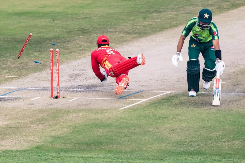 Zimbabwe's wicketkeeper Regis Chakabva  attempts a run-out of Pakistan's Babar Azam  during the second T20 at the Harare Sports Club. Zimbabwe bowled Pakistan out for 99 to win the match by 19 runs.  AFP