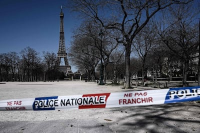 TOPSHOT - A limit set up by the national police is seen at the entrance of a closed park in front of the Eiffel tower in Paris  on March 23, 2020, as the country is under lockdown to stop the spread of Covid-19 disease caused by the novel coronavirus.  / AFP / PHILIPPE LOPEZ
