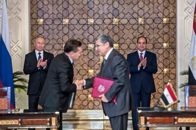 Egyptian President Abdel Fattah El Sisi, back right, and his Russian counterpart Vladimir Putin, back left, applaud as Egypt's electricity and renewable energy minister, Mohamed Shaker, right, and Alexei Likkhachev, director general of Russia's Atomic Energy Corporation sign an agreement in 2017. AFP