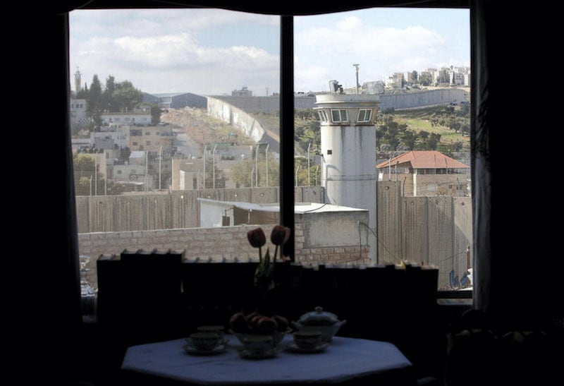 epa05830153 A view through a window from inside the Walled Off Hotel by British street artist Banksy in the West Bank city of Bethlehem, 04 March 2017. The hotel in the Palestinian territories is placed only a couple of meters from Israel's separation wall with all rooms facing it. The Walled Off Hotel will open for guests on 20 March, with bookings via the website.  EPA/ABED AL HASHLAMOUN *** Local Caption *** 53369059