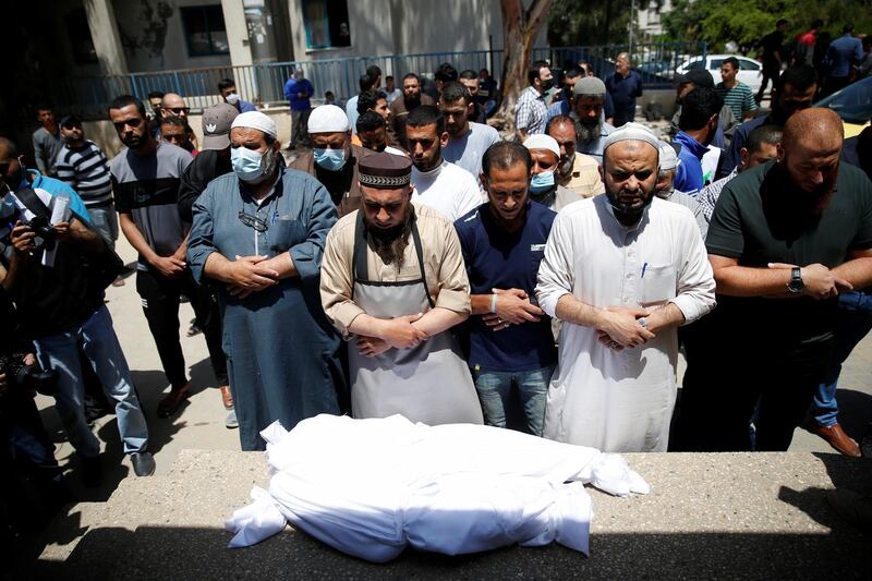 Palestinians mourn deceased relatives, at the site of Israeli air strikes, in Gaza City. Reuters