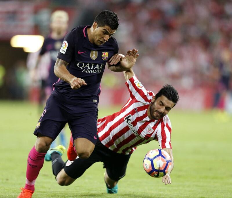Athletic Bilbao defender Eneko Boveda, right, fights for the ball with Barcelona striker Luis Suarez. Miguel Tona / EPA