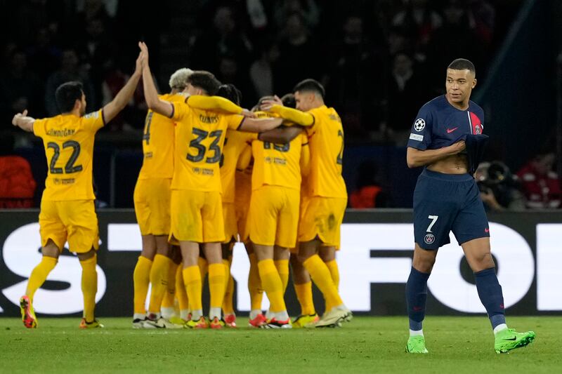 PSG's Kylian Mbappe, right, gestures as Barcelona players after their teammate Andreas Christensen scored his side's third goal during the Champions League quarterfinal first leg soccer match between Paris Saint-Germain and Barcelona at the Parc des Princes stadium in Paris, Wednesday, April 10, 2024.  (AP Photo / Lewis Joly)