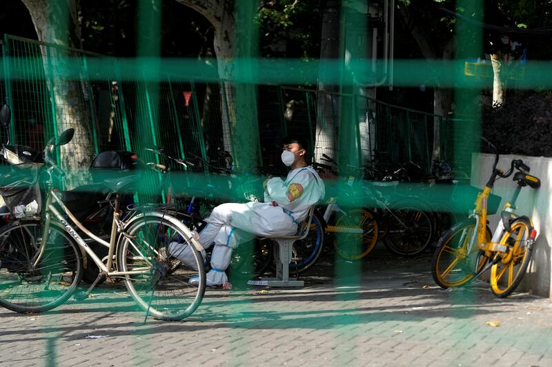 A worker in a protective suit sits in a sealed area amid new lockdown measures to curb the coronavirus outbreak in Shanghai, China. Reuters