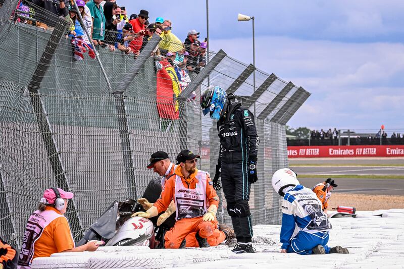 Mercedes driver George Russell checks on Guanyu Zhou. EPA