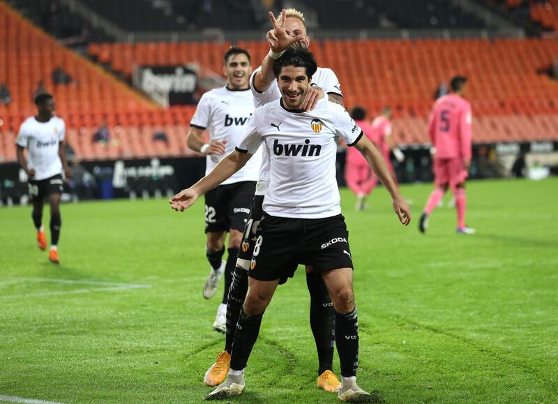 VALENCIA, SPAIN - NOVEMBER 08: Carlos Soler of Valencia celebrates with teammate Uroc Racic after scoring his team's fourth goal  during the La Liga Santander match between Valencia CF and Real Madrid at Estadio Mestalla on November 08, 2020 in Valencia, Spain. Sporting stadiums around Spain remain under strict restrictions due to the Coronavirus Pandemic as Government social distancing laws prohibit fans inside venues resulting in games being played behind closed doors. (Photo by Angel Martinez/Getty Images)