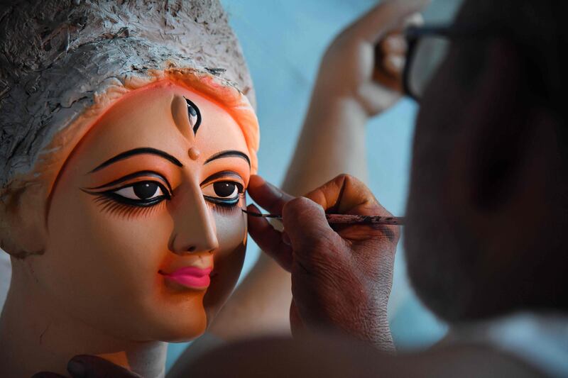 An artist gives the final touches to a clay sculpture depicting the Hindu goddess Durga at a workshop in Guwahati before the pan-India festival begins on Thursday. AFP