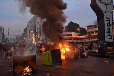 Lebanese anti-government protesters burn dumpsters to block al-Nour Square in Lebanon's northern port city of Tripoli on January 26, 2021, as anger grows over a total lockdown aimed at stemming an unprecedented spike in coronavirus cases. / AFP / -