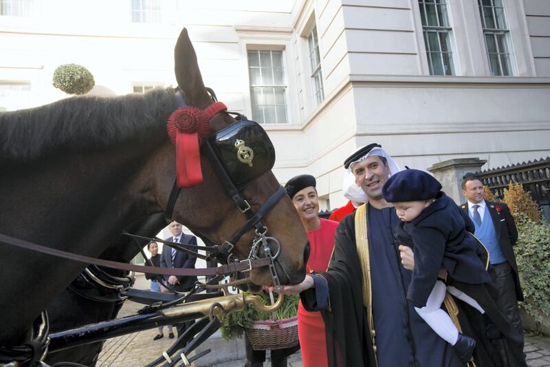 His Excellency Mansoor Abdulhoul following his visit with Her Majesty The Queen at Buckingham Pallace for the presentation of diplomatic credentials. Seen here with his wife in red with black hat, Victoria Devin and the deputy Marshal of the Diplomatic Core with feathers in hat. Outside the Lanesborough Hotel in central London where the reception HE Mansoor Abdulhoul's in D'honneur took place.