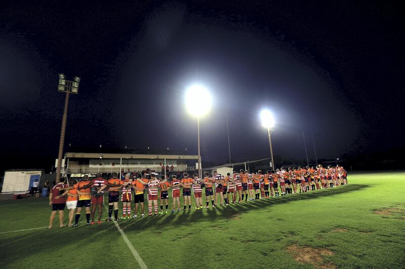 Sharjah, June, 01, 2018: RAK Rugby ( Red& White ) and  Arabian Knights ( Orange& BlacK) observes minute's silence for Nick Young, a RAK player who died after an on-field accident recently during the Nick Young Memorial match at the Sharjah Wanderers sports club in Sharjah . Satish Kumar for the National / Story by Paul Radley