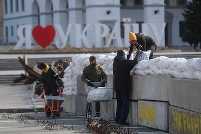 People set up a barrier of sandbags in downtown Kyiv on March 11. The UN refugee agency says over 2.5 million people have left Ukraine since the invasion began on February 24. But many have decided to stay. EPA