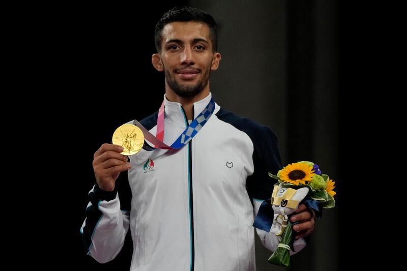 Iran's Mohammedreza Geraei on the podium after winning gold in the men's 67kg Greco-Roman wrestling.
