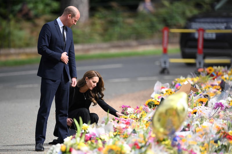 Britain's Prince William, Prince of Wales and Britain's Catherine, Princess of Wales look at floral tributes outside Norwich Gate on the Sandringham Estate in Sandringham, eastern England, on September 15, 2022, following the death of Queen Elizabeth II.  - As preparations build for next week's state funeral, Prince William and his wife Catherine -- the new Prince and Princess of Wales -- visit Sandringham, where the queen used to spend Christmas.  (Photo by Daniel LEAL  /  AFP)