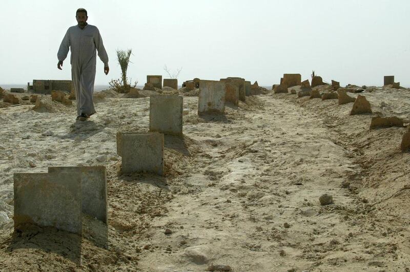 An Iraqi man walks through old and recent graves at a cemetery in Sahl, 350 kilometres north-west of Baghdad. Ramzi Haidar / AFP