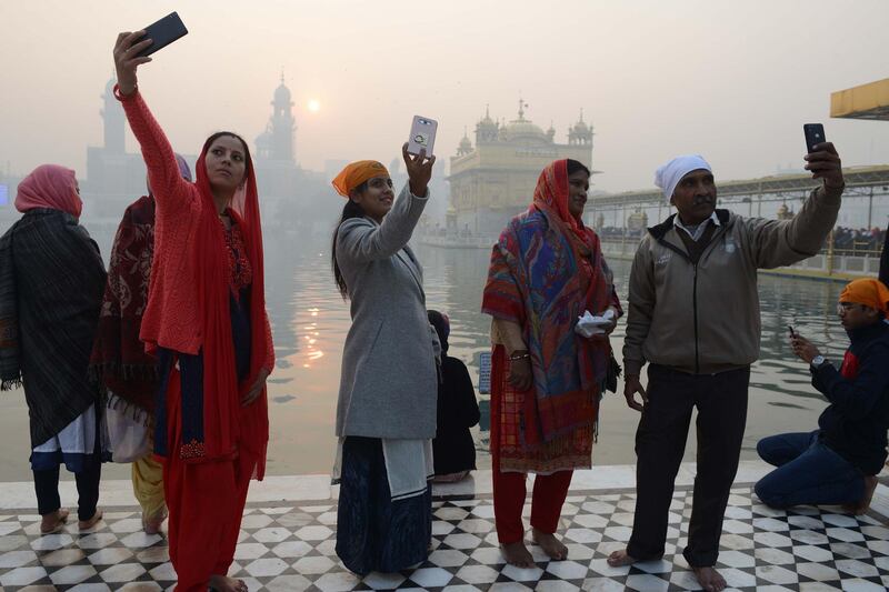 Indian devotees take selfies  at the Golden temple in Amritsar. Narinder Nanu / AFP Photo