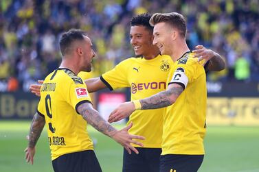 Marco Reus, right, celebrates with Jadon Sancho, centre, and Paco Alcacer after scoring his team's sparkling second goal against Bayer Leverkusen on Saturday in the Bundesliga. Getty