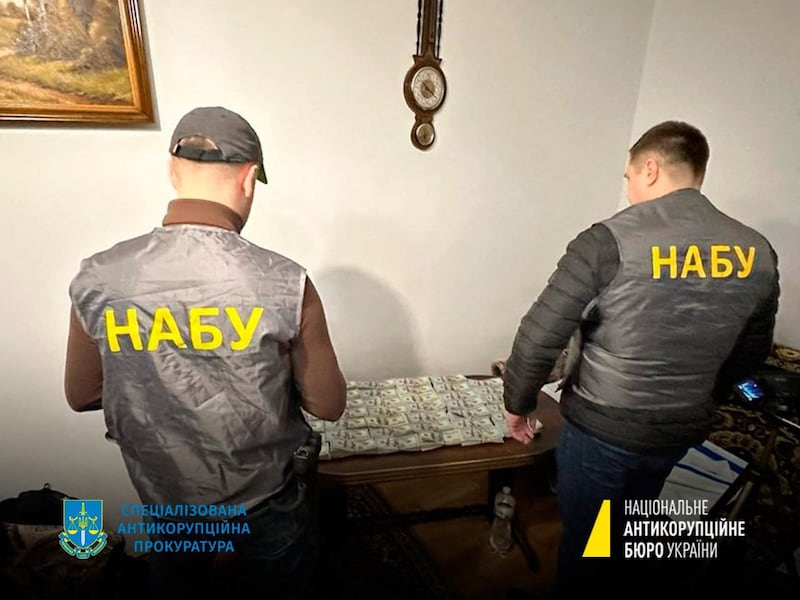 Officials from Ukraine's National Anti-Corruption Bureau stand next to seized money. AFP