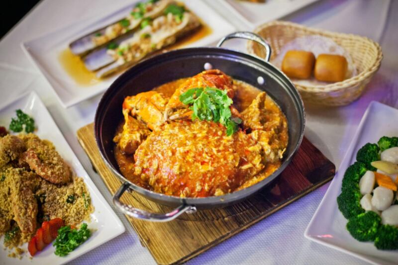 A dish of chili crab, center, sits among other dishes on a table at the Jumbo Seafood Riverside restaurant, operated by Jumbo Group, at Clark Quay in Singapore, on Monday, Oct. 6, 2015. Jumbo Group, a restaurant chain specializing in seafood, aims to expand its regional presence using proceeds from an upcoming public offer. Photographer: Sam Kang Li/Bloomberg