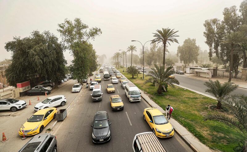 Vehicles drive along a road during a severe dust storm in Baghdad. AFP