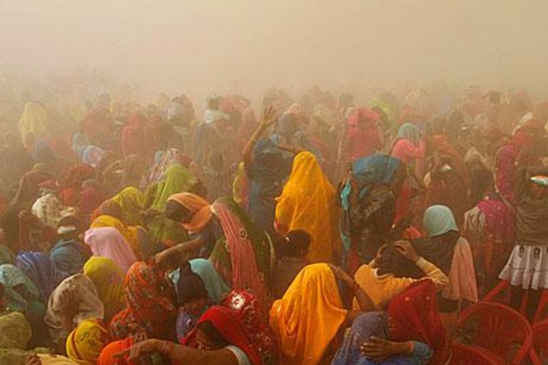 Indians cover their faces as the helicopter of the Congress Party's Uttar Pradesh candidate, Rahul Gandhi, leaves an election rally in Basti.