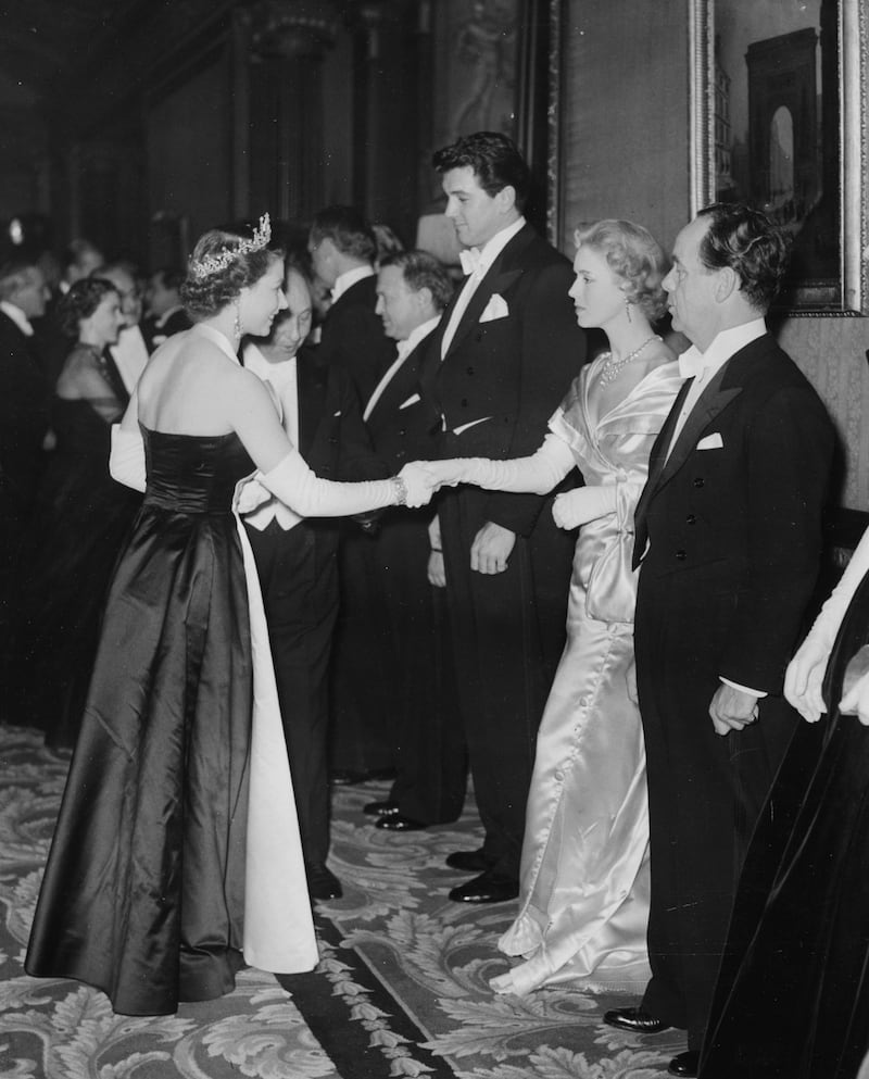 She meets actress Veronica Hurst and actor Rock Hudson at the Royal Film Performance in London in 1952. Getty
