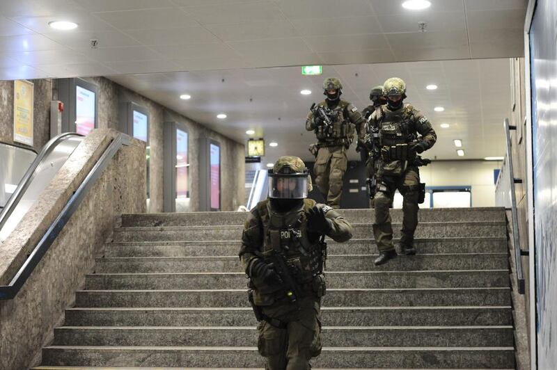 Heavily armed police forces walk through the Karlsplatz underground station in Munich on July 22, 2016. Andreas Gebert / dpa via AP