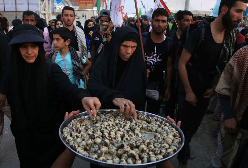 Shiite Muslim pilgrims help themselves to a snack as they walk in the holy Iraqi city of Karbala. AFP