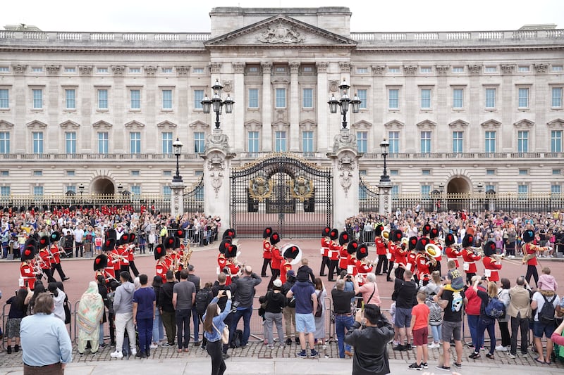 Members of the public watch the Band of the Coldstream Guards marching during the Changing the Guard ceremony at Buckingham Palace in London. PA