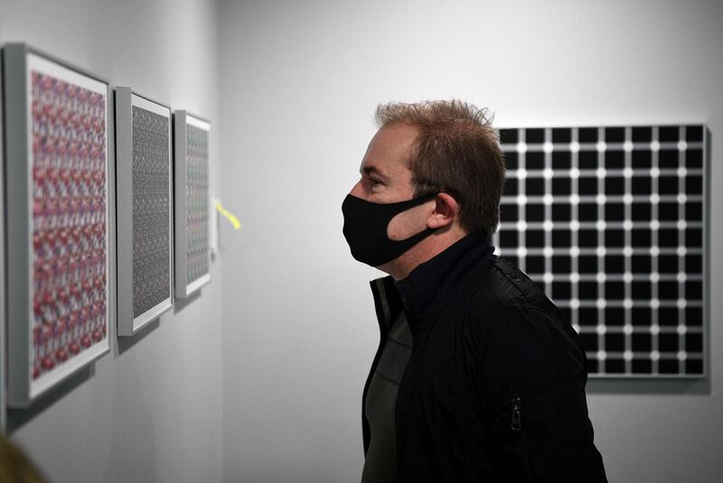 A man wearing a protective mask looks at art in the Museum of Illusion in Paris.  AFP