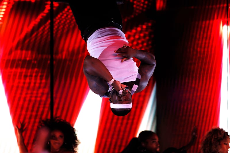 50 Cent performs his 2003 hit 'In da Club' while hanging upside down and dressed in a white tank top, like in the song's music video. EPA