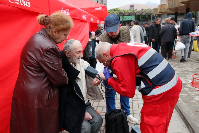 A medic helps an Armenian man from Nagorno-Karabakh near the registration and distribution centre in Goris. EPA
